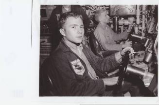 Black and white photograph of two sailors sitting at the helm of the submarine USS Growler
