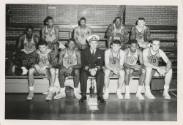 Black and white photograph of USS Intrepid's basketball team in uniform with the ship's captain