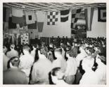 Black and white photograph of a prayer service on USS Intrepid's hangar deck