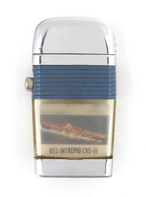 Lighter with blue plastic grips and push button on one side, body depicts colored image of USS …