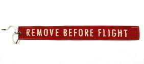 Red safety warning ribbon with the words "remove before flight" printed in white