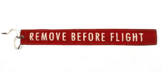Red safety warning ribbon with the words "remove before flight" printed in white