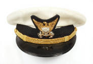 U.S Coast Guard dress cap with white top, black visor and gold officer crest depicting an eagle…