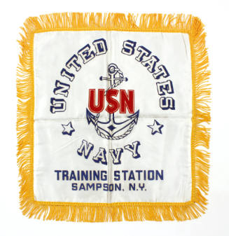 White souvenir pillowcase with gold fringe, with the words "United States Navy, Training Statio…