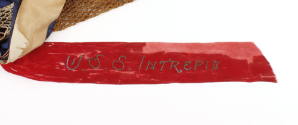 Red ribbon with "USS Intrepid" blue embroidered text