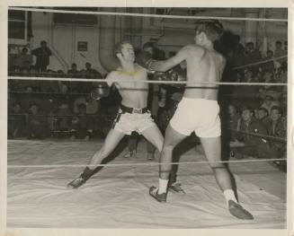 Black and white photograph of James Grove in a boxing match on the hangar deck