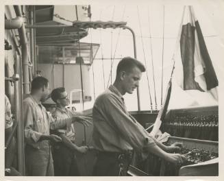 Black and white photograph of three enlisted men on Intrepid's signal bridge