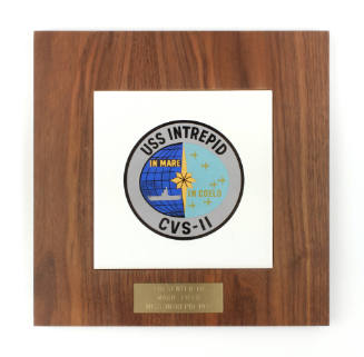 Square plaque with an inset white ceramic tile that depicts circular USS Intrepid seal, metal l…