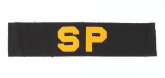 Navy blue shore patrol armband with “SP” sewn on the front center in yellow block letters