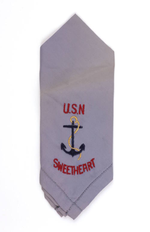 Folded faded blue handkerchief with “U.S.N. Sweetheart” embroidered in red and navy blue fouled…