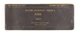 Printed manual with black cover and gold lettering that reads "Training Aid Booklet - Volume 1 …