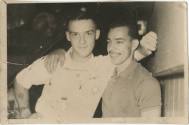 Black and white photograph of two men with their arms around each other's shoulders