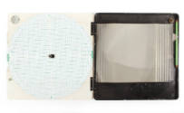 Plotting board open to show interior of case, one side is white with green concentric circles, …