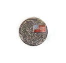 Circular commemoration pin depicting the surface of the moon with a colored American flag in th…