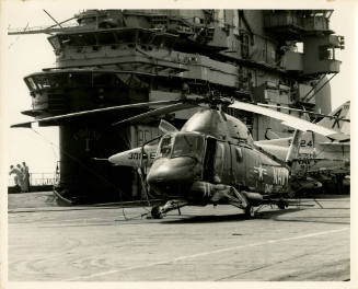 Black and white photograph of a helicopter on aircraft carrier USS Intrepid's flight deck, with…