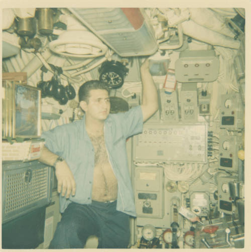 Printed color photograph of a sailor in the engine room control booth in the submarine USS Grow…
