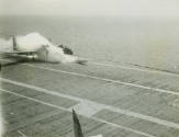 Black and white photograph of a Douglas AD-6 Skyraider in a plume of smoke after a fuel tank fe…