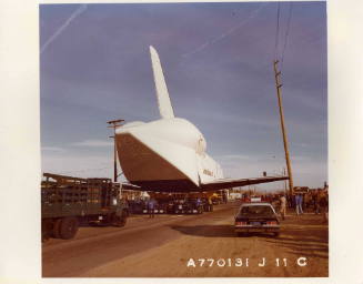 Color photograph of rear view of Enterprise being towed
