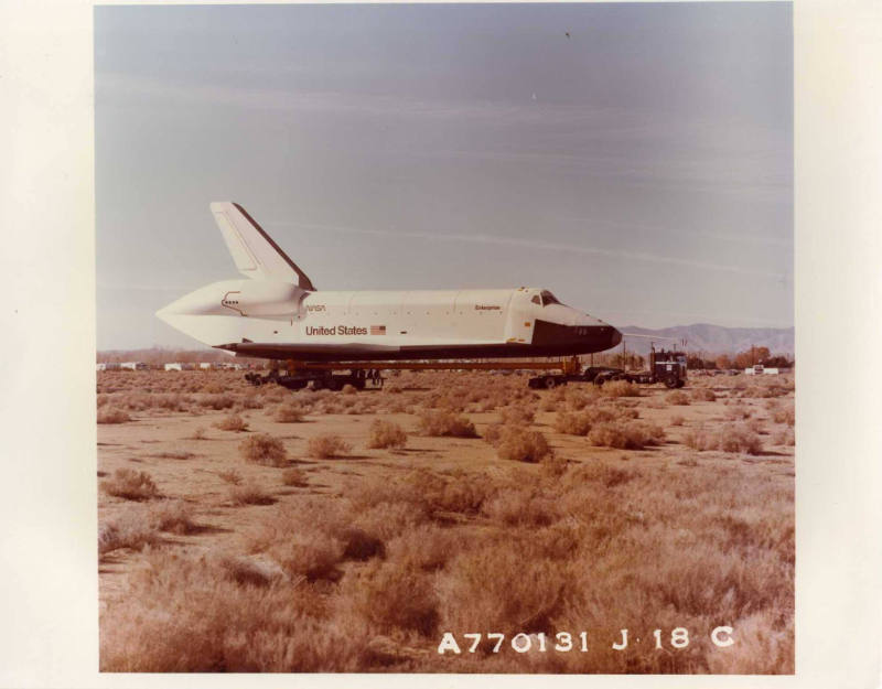 Color photograph of Enterprise being towed with open land on Edwards Air Force Base