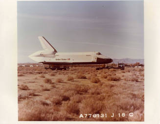 Color photograph of Enterprise being towed with open land on Edwards Air Force Base