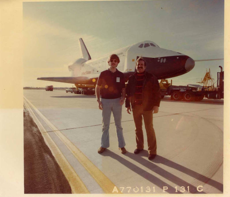 Color photograph of two men standing in front of Enterprise