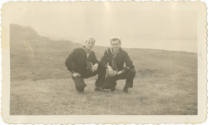 Black and white photograph of two sailors in dress blue uniforms posing in a field