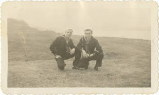 Black and white photograph of two sailors in dress blue uniforms posing in a field