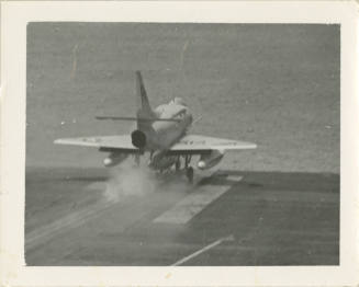 Printed black and white photograph of a Douglas A-4C Skyhawks taking off on the flight deck
