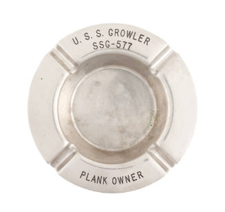 Circular metal ashtray with inscription "USS Growler SSG-577 Plank Owner" around rim
