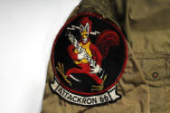 Detail of circular Attack Squadron 66 insignia patch with red rooster holding an anti-aircraft …