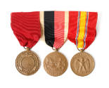 Three round bronze service medals on a ribbon bar