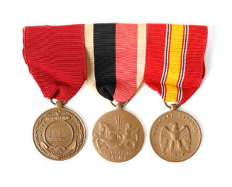 Three round bronze service medals on a ribbon bar