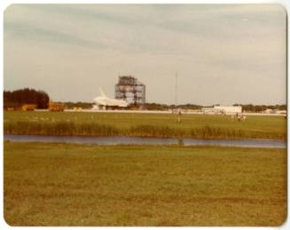 Color photograph of Space Shuttle Enterprise on a runway with grass and a river in the foregrou…