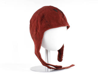 Red canvas flight deck cap with chin strap and buckle on mannequin head form