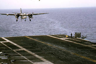 Color photograph of a Grumman S-2E Tracker coming in for a landing on the flight deck