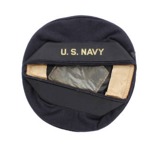 Dark blue round flat hat with "U.S. Navy" in gold on the hatband ribbon