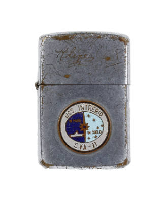 Silver lighter with circular colored enamel USS Intrepid seal on base below lid