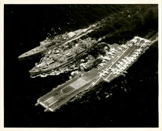 Black and white photograph of an oiler refueling USS Intrepid and another ship at sea