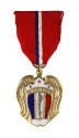 Front of Philippine Liberation Medal that has gold arched wings flanking a shield with a sword …