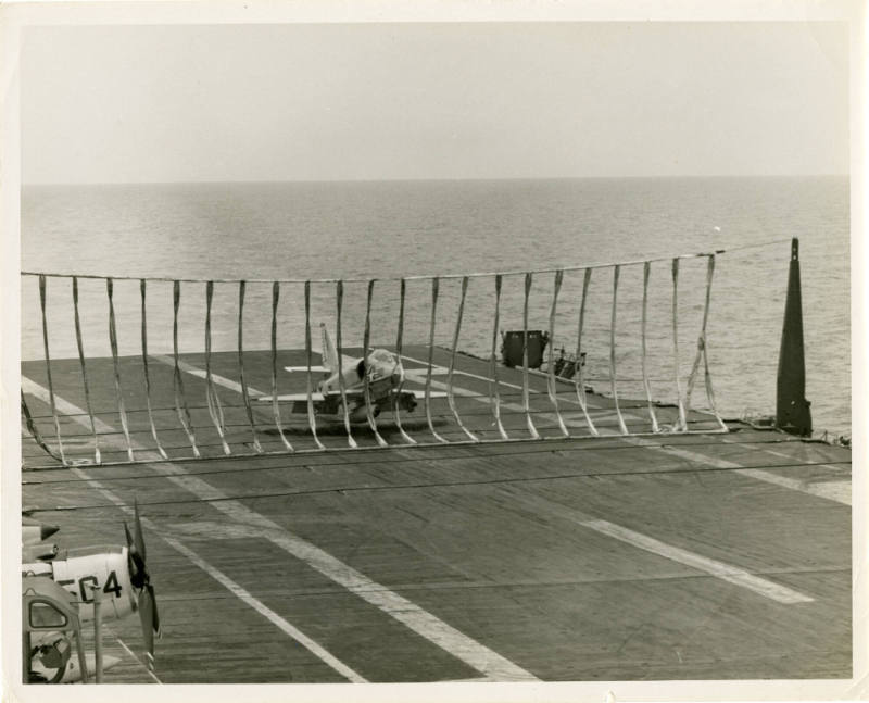 Black and white photograph of an A-4 Skyhawk about to crash into the flight deck barricade net