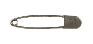 Silver metal safety pin with "A8" engraving on clasp