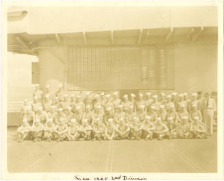 Black and white group photograph of USS Intrepid's second division posed in three rows on the f…