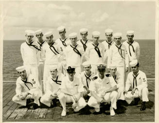 Black and white group photograph of the OA Division on USS Intrepid's flight deck dated August …