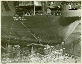 Black and white photograph of USS Intrepid in dry dock with a jury rudder