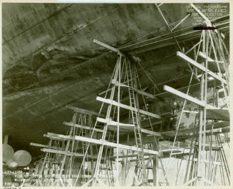 Black and white photograph of the bottom of USS Intrepid in dry dock 