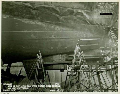 Black and white photograph of the bottom of USS Intrepid in dry dock to repair torpedo damage