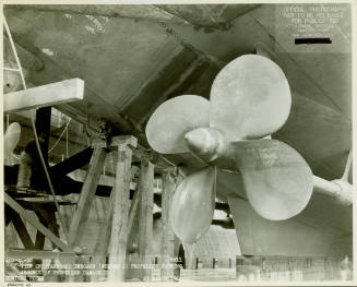 Black and white photograph of number 2 propeller on USS Intrepid in dry dock