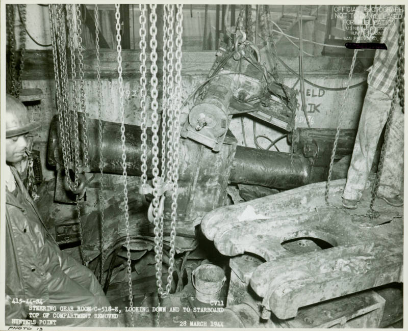 Black and white photograph of steering gear room on USS Intrepid during repairs