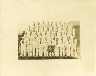 Black and white group photograph of gunner's mate school sailors standing on bleachers in four …