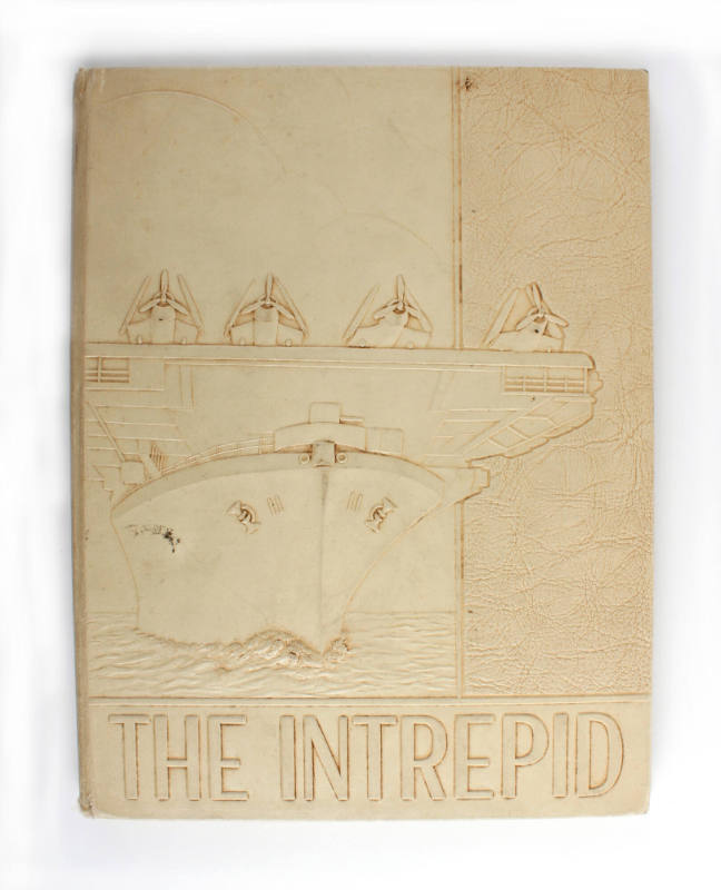 Tan hardcover USS Intrepid cruise book for 1943 with a raised image of USS Intrepid and aircraf…